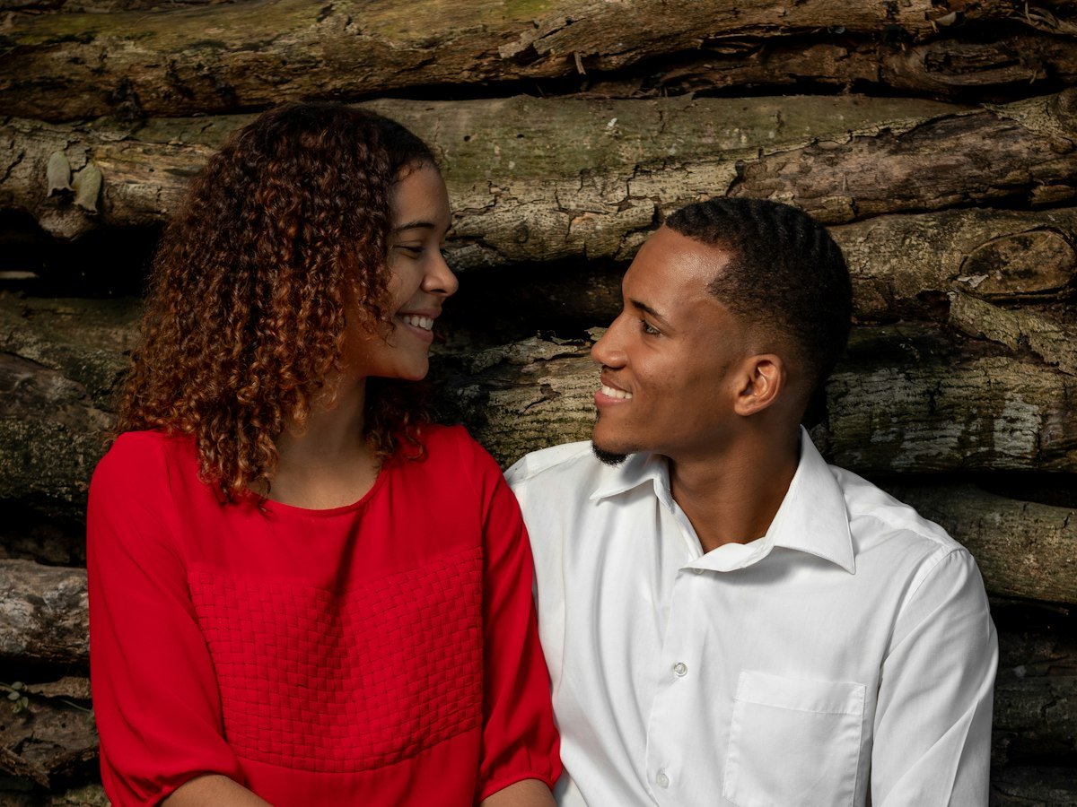 A couple sitting close together, smiling at each other